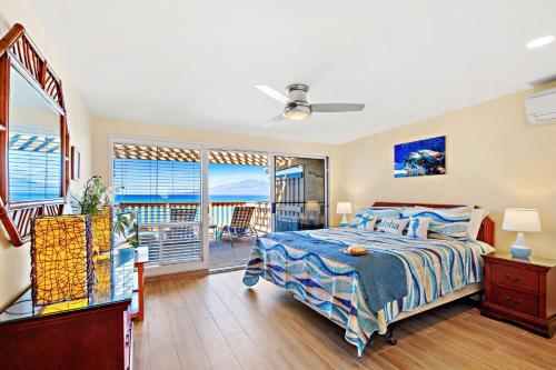 een slaapkamer met een bed en een balkon bij Oceanfront & Sunsets! ks a5- Sullivan in Kahana