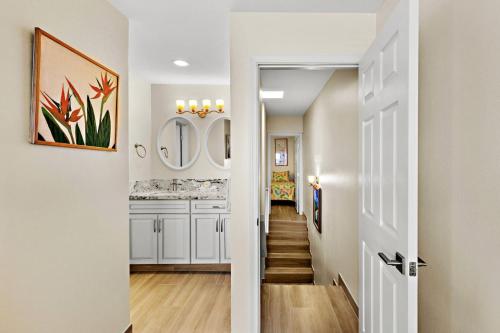 een hal met witte muren en een trap met een spiegel bij Oceanfront & Sunsets! ks a5- Sullivan in Kahana