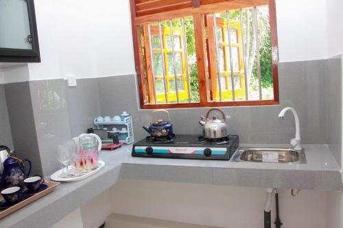 a kitchen with a stove and a sink and a window at Calm Nature Resort in Midigama