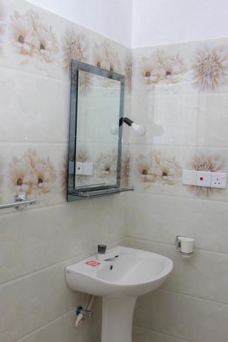 a white bathroom with a sink and a mirror at Calm Nature Resort in Midigama