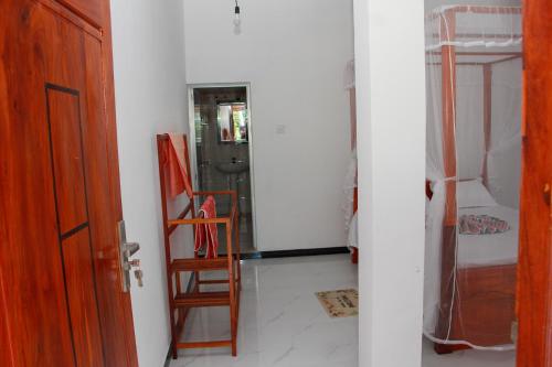 a hallway with a room with a door and a chair at Calm Nature Resort in Midigama