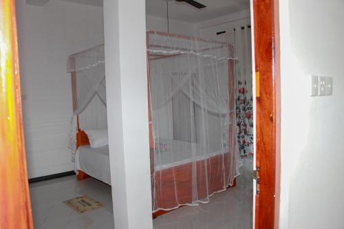 a bedroom with a bed and a window at Calm Nature Resort in Midigama