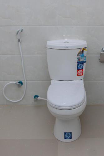 a white toilet in a bathroom with a hose at Calm Nature Resort in Midigama