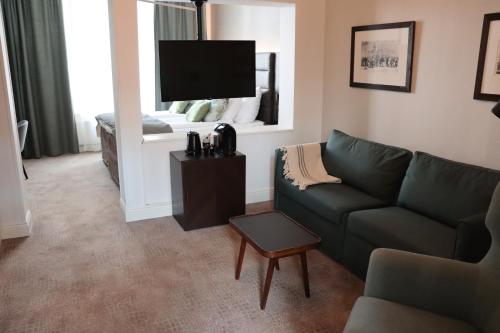 a living room with a couch and a flat screen tv at Home Hotel Victoria in Jönköping