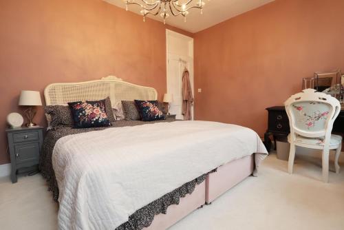 a bedroom with a bed and a chair and a chandelier at Spacious 2-Bed Cardiff Haven with Luxe Touches in Cardiff