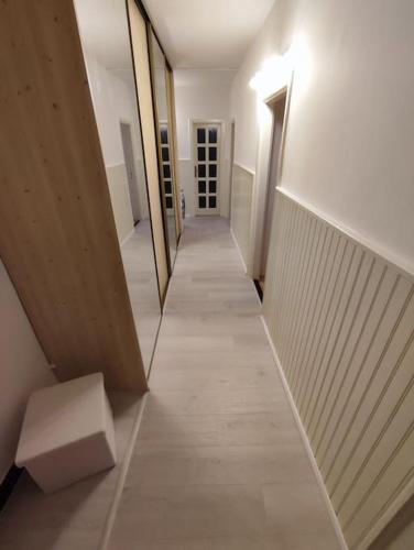a hallway with a mirror and a bench in a building at Priestranný apartmán- s vynikajúcou dostupnosťou in Nivy