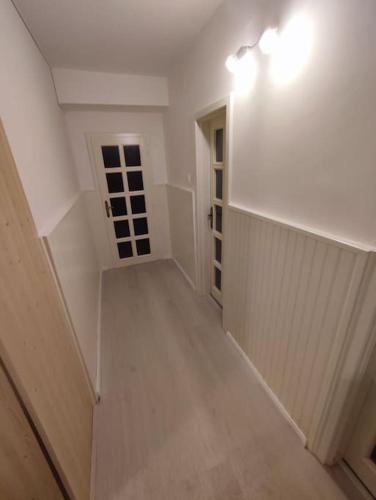 an empty hallway with a door and a light on the wall at Priestranný apartmán- s vynikajúcou dostupnosťou in Nivy