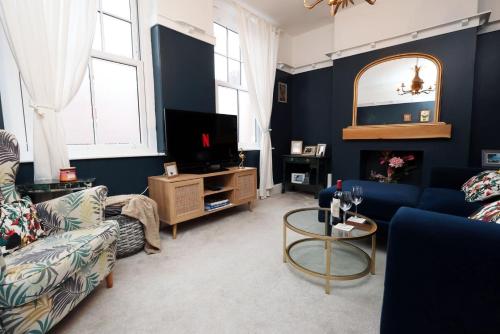 a living room with a couch and a tv at Spacious 2-Bed Cardiff Haven with Luxe Touches in Cardiff