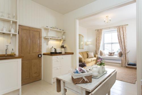 a kitchen with a table and a living room at Romantic cottage with fantastic coastal views in Marazion