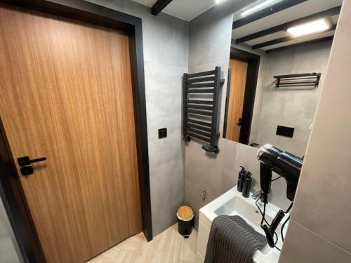 a bathroom with a wooden door and a sink at Pod Błękitnymi Podkowami in Wrocław
