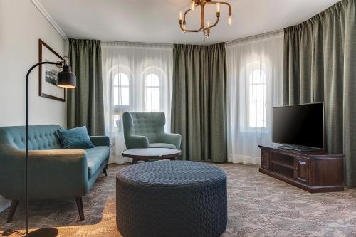 a living room with a couch and a tv at Home Hotel Victoria in Jönköping