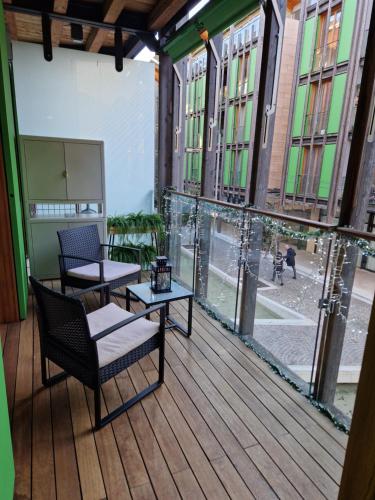 a balcony with two chairs and tables and windows at La Casa di Vale Muse in Trento
