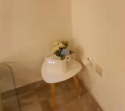 a white table with a flower sitting on top of it at Belle maison familiale spacieuse à Dakar Sénégal HOME TERANGA in Dakar