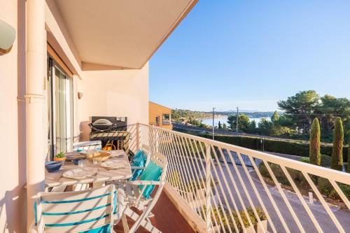 un balcon d'une maison avec une table et des chaises dans l'établissement Appartement Éclat Marin - Welkeys, à Bandol