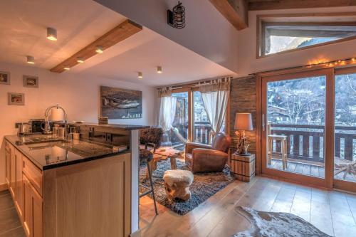 une cuisine avec un évier et un salon dans l'établissement Belvédère du Brévent - Welkeys, à Chamonix-Mont-Blanc