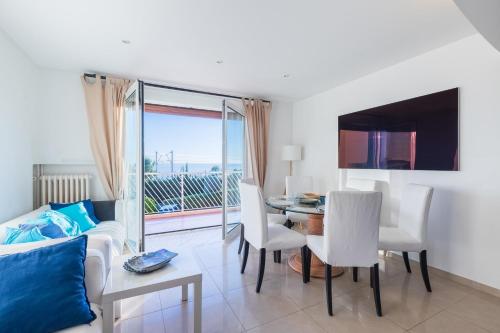 un salon avec un canapé, une table et des chaises dans l'établissement Appartement Éclat Marin - Welkeys, à Bandol