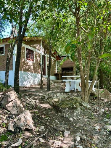 a bench in front of a house with trees at Atrapa Sueños I in Embalse