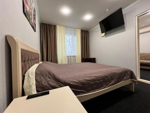 a hotel room with a bed and a table at Готельно-ресторанний комплекс Поділля in Bershadʼ