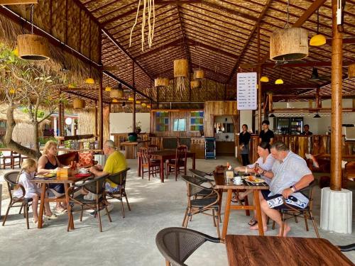 a group of people sitting at tables in a restaurant at Andaman Beach Resort by Zodiac in Ko Lipe