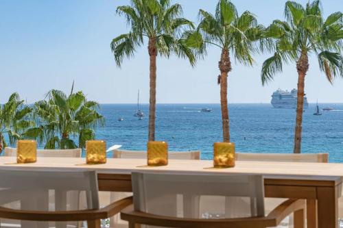 - une table avec des chaises et une vue sur l'océan dans l'établissement 1973 - Luxurious waterfront apartment Croisette, à Cannes