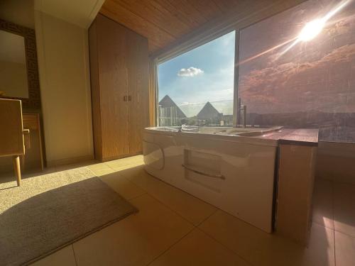 a bathroom with a sink and a large window at DouDou Pyramids View Hotel in Cairo