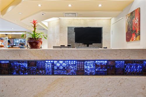 a lobby with a bar with blue glass counter tops at Luana Waikiki Hotel & Suites in Honolulu