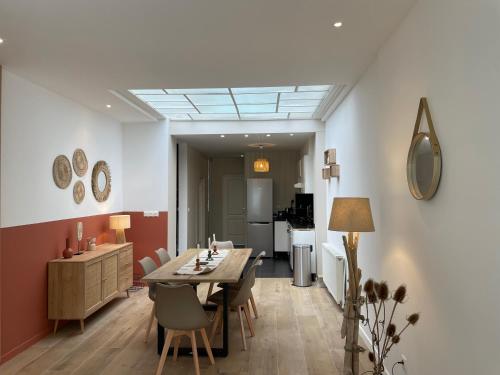 une salle à manger et une cuisine avec une table et des chaises dans l'établissement Maison de ville - près de LILLE, à Mouvaux