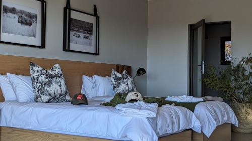 a white bed with hats on top of it at Umlingo Lodge in Melkrivier