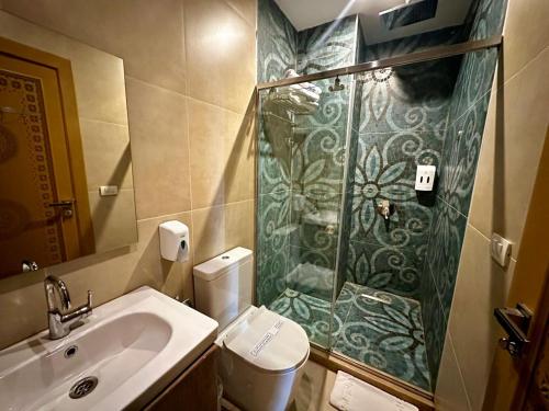 a bathroom with a shower and a toilet and a sink at DouDou Pyramids View Hotel in Cairo
