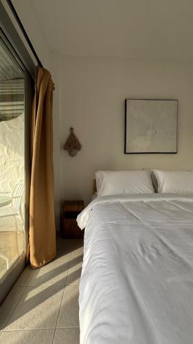 苏梅岛Coffee Connextions Cafe & Rooms的卧室里有一张白色的大床和一扇窗户