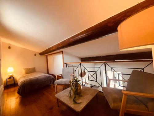 une chambre avec un lit, un canapé et une table dans l'établissement Appartement Le Phénix, à Nîmes