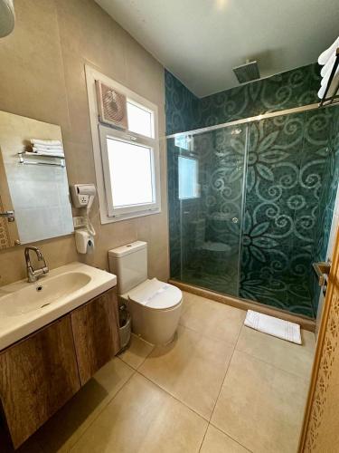 a bathroom with a shower and a toilet and a sink at DouDou Pyramids View Hotel in Cairo