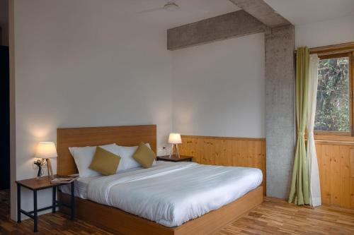 a bedroom with a large bed and a window at StayVista at Gassa Home with Mountain View, BBQ, Lawn at Gangtok in Gangtok
