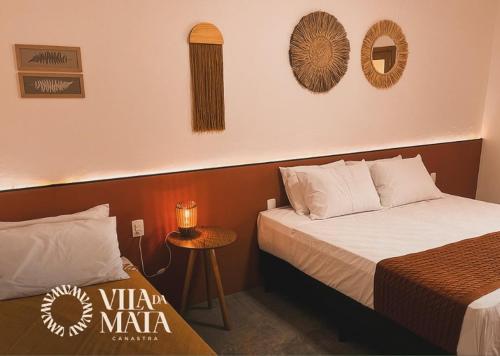 a hotel room with two beds and a table at Pousada Vila da Mata - Canastra in São João Batista do Glória