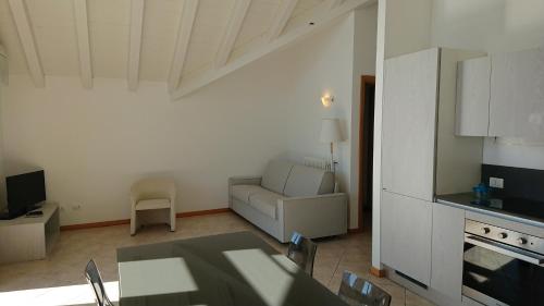 a kitchen and a living room with a table and a couch at Lakecomoweb Apartments in Perledo