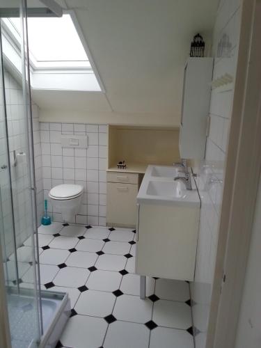 a white bathroom with a sink and a toilet at Appartementen Zandvoort in Zandvoort