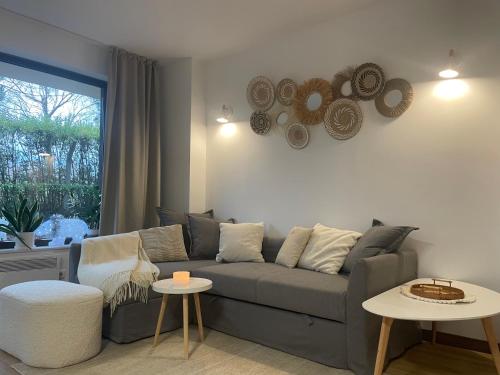 a living room with a gray couch and two tables at Ground floor 2-bedrooms, 2-bathrooms apartment near Bansko in a complex with pools and SPA included in Razlog