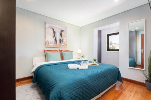 a bedroom with a large bed with a blue blanket at Host Wise - Charming Cozy Rooms in São Mamede de Infesta