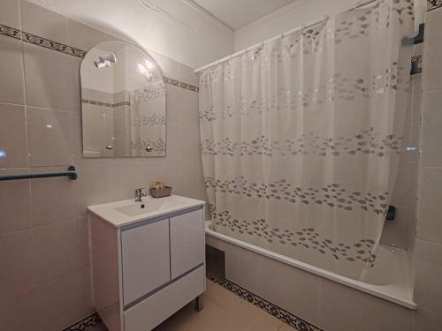 a bathroom with a sink and a shower curtain at 4D Torre Rafael - Casas & Papéis in Armação de Pêra