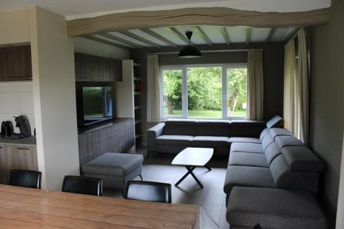 a living room with a couch and a table at Chez Ines in Marloie