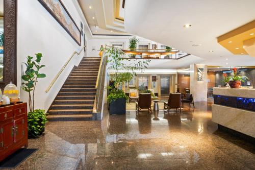 a lobby of a hotel with stairs and chairs at Luana Waikiki Hotel & Suites in Honolulu