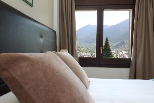 a bedroom with a bed and a window with a view at Hotel Blu Aran in Vielha