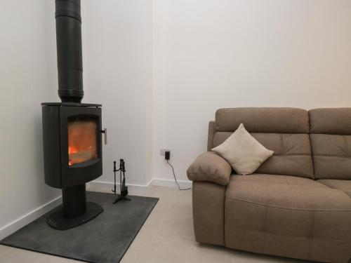 a living room with a couch and a wood stove at Apple Tree Barn in Dalton in Furness