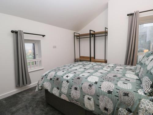 a bedroom with a bed with a green and white bedspread at Apple Tree Barn in Dalton in Furness