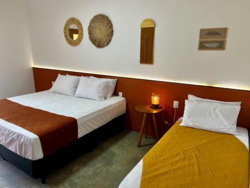 a bedroom with two beds and a mirror on the wall at Pousada Vila da Mata - Canastra in São João Batista do Glória