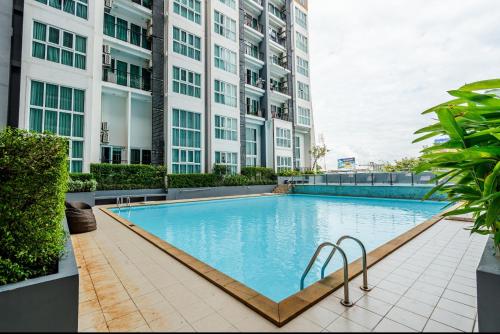 a large swimming pool in the middle of a building at Stay with Pano at The Prio Condo in Chiang Mai