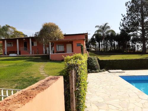 a house with a swimming pool in front of it at Chácara Treviso in Ibiúna