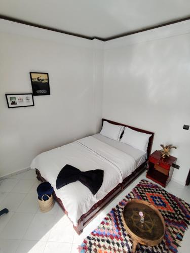 a bedroom with a bed with a bow tie on it at Locals Taghazout surfcamp in Taghazout