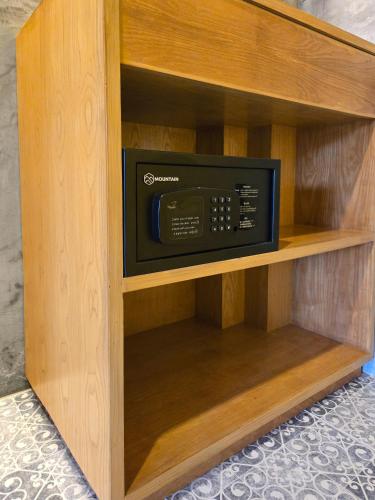 a wooden cabinet with a microwave oven in it at At Home Khaolak in Khao Lak