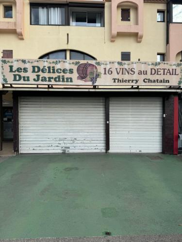 ein Gebäude mit zwei Garagentüren und einem Schild darauf in der Unterkunft T 2 cosy bord de mer in Le Barcarès